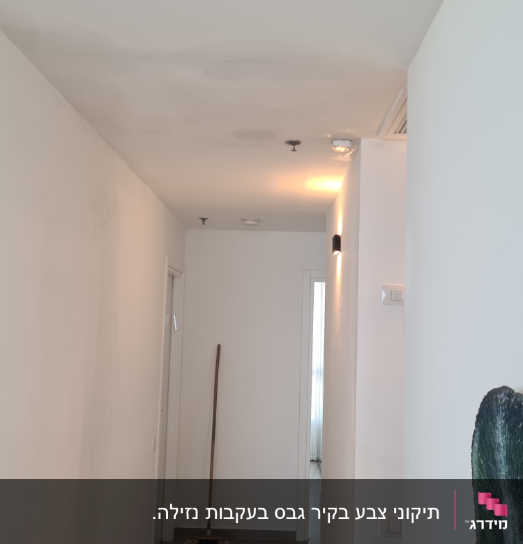 מסדרון עם קיר צבוע ולוח צבעים על הרצפה